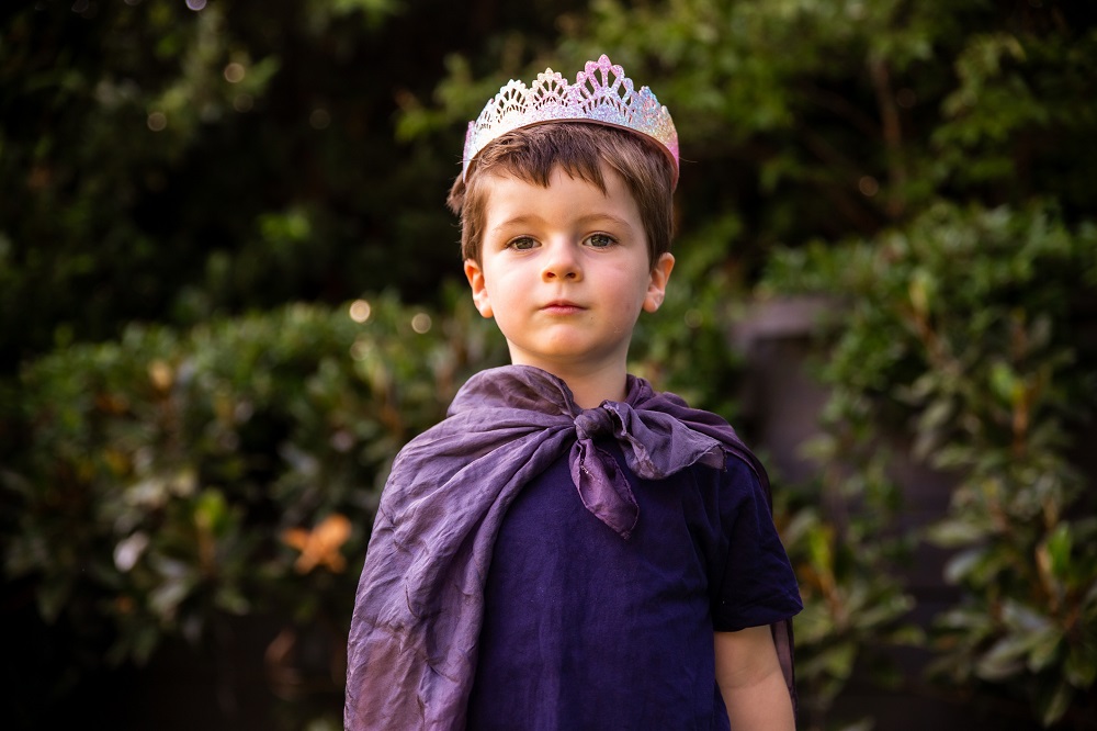 Young boy dressed up in a cloak and crown