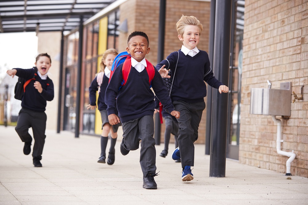 Happy children running into school