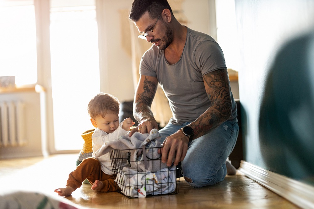 Dad and toddler having fun sorting out the washing