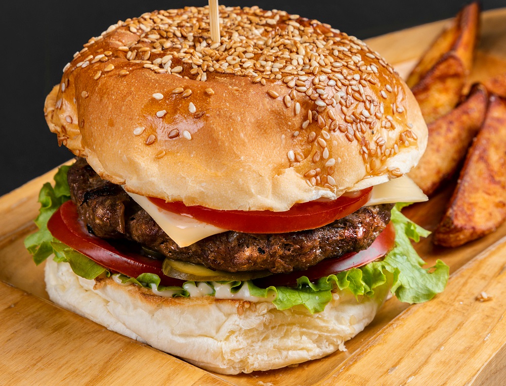 Burger in a bun with lettuce and tomato