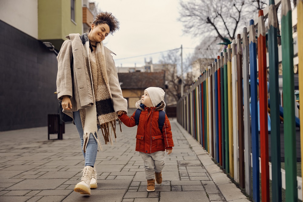 Mum and young child walking to nursery, talking together