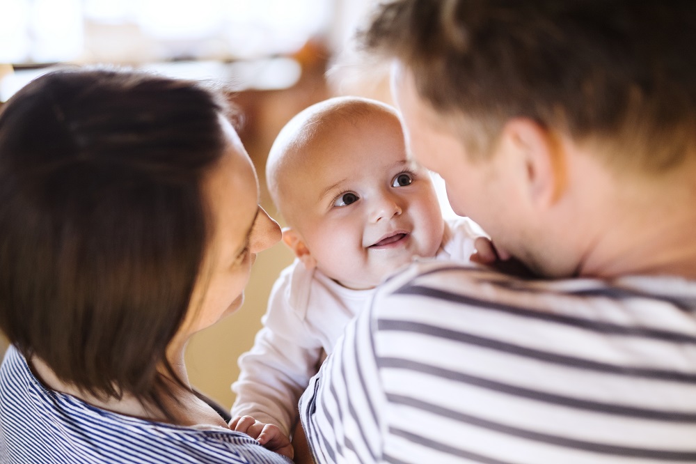 Mum and dad holding baby up so they can chat face to face