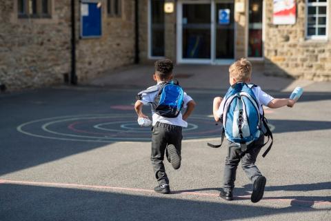 Two boys running in a school playground