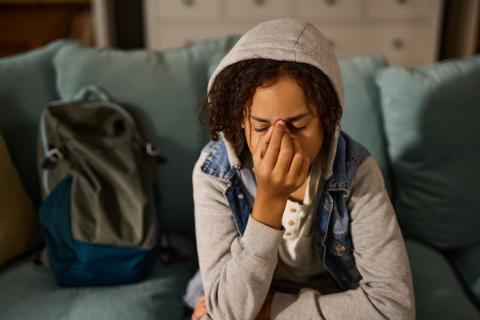 Stressed teenager covering their face with their hand