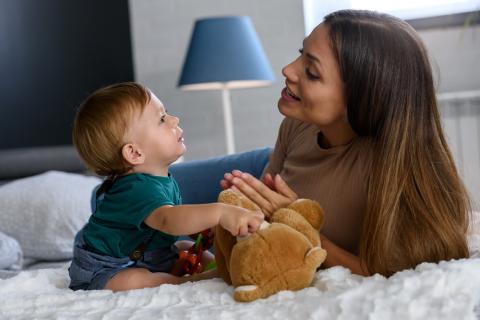 Mum and baby chatting together, holding a teddy bear